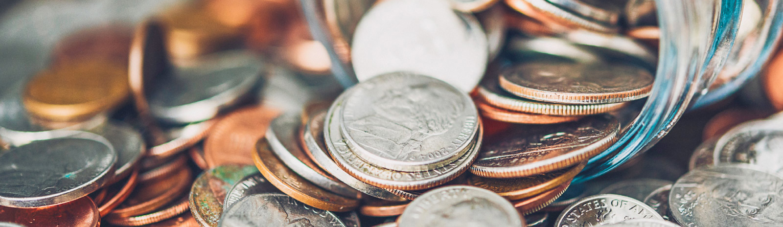 coins pouring out from a glass jar