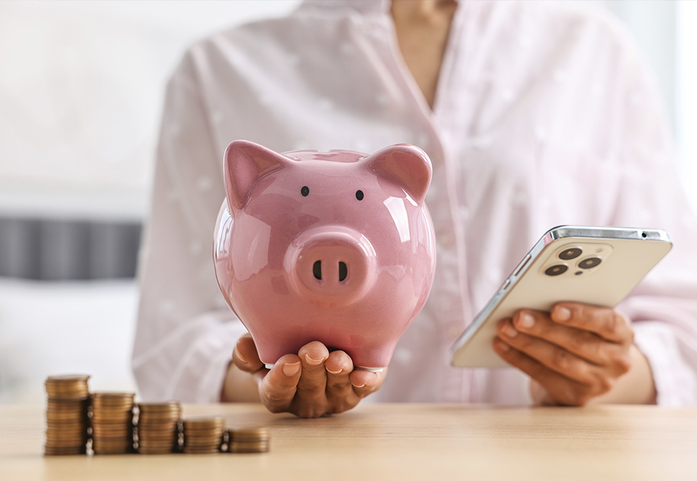 woman holding piggy bank near stacks of coins